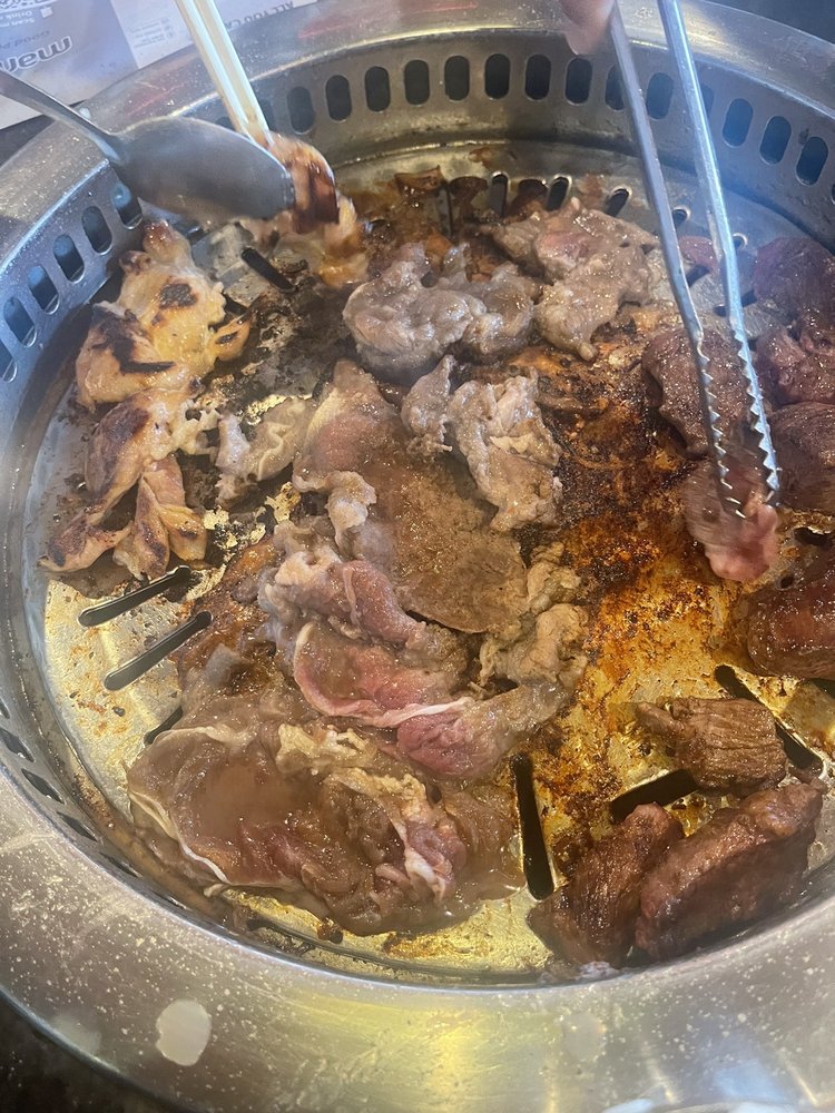 Thin-sliced meat cooking on the round table grill